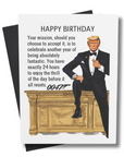 A birthday card with a humorous illustration of POTUS resembling a famous spy in a tuxedo, sitting on a desk. The text on the card reads: 'HAPPY BIRTHDAY.