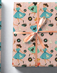 Vintage rock and roll wrapping paper with records and milkshakes and girls in poodle skirts dancing, pink background with pastels top view