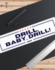 Sticker with 'DRILL, BABY, DRILL! 2025' text on a black surface with a ruler and pens.
