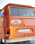 Orange van with 'DRILL BABY, DRILL!' sticker on a blurred background