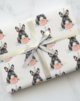 Birthday wrapping paper featuring a french bulldog with a present on a light background.