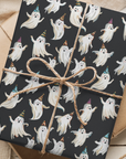 Party ghosts Halloween wrapping paper featuring smiling ghosts in colorful birthday hats on dark background