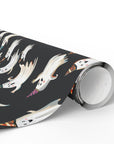 Roll of wrapping paper Halloween and birthday themed featuring smiling ghosts in colorful birthday hats on dark background