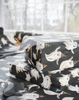 Halloween and birthday themed gift wrap featuring smiling ghosts in colorful birthday hats on dark background