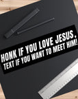 Black bumper sticker with white text on a black surface with pens and a ruler.