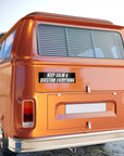Orange vintage van with a 'Keep Calm & Question Everything' sticker on a blurred background