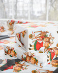 Christmas-themed gift wrap with reindeer and little girl kiss on a white background side view