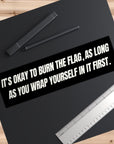 Black mat with text and stationery items on a wooden surface