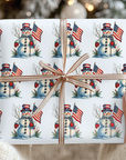 a box that is wrapped in a christmas design that features a snowman and american flag against a light blue background