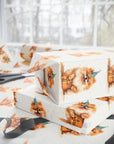 Gift boxes wrapped in birthday themed Pomeranian paper with scissors on a matching surface.