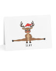 Card with a reindeer doing a split and wearing a Santa hat on a white background
