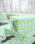 Spring wrapping paper with baby chicks nestled inside yellow flowers and butterflies on aqua background