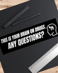 Sticker with text 'This is your brain on drugs. Any questions?' on a black background with pens and a ruler.