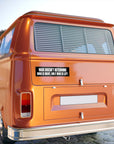 Orange van with a black bumper sticker on a blurred background