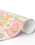 Pastel baby quilt wrapping paper roll with patchwork nursery design in soft pink blue and cream tones.