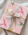 Pink wrapping paper with colorful birds flying and soft feathers scattered throughout.