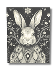 Decorative illustration of a black and white rabbit illustration on a dark background with floral elements.
