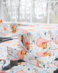 Gift wrap with baby and cherry blossom design on a table with scissors