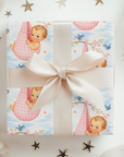 Gift box with baby-themed wrapping paper and a pink bow, surrounded by decorative stars.