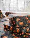 Christmas gift boxes wrapped in paper featuring Santa relaxing in beer, whiskey, margarita, and champagne glasses on black background with holly
