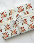 Vintage Valentine’s Day wrapping paper with Cupid angel and hearts on pale blue background