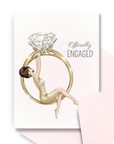 Engagement card for bride to be with brunette bride swinging from large diamond ring illustration with coordinating pink envelope.