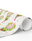 Roll of birthday wrapping paper with a colorful frog pattern on a white background.