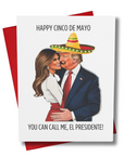 This image features a whimsical Cinco de Mayo greeting card, titled "Happy Cinco De Mayo, You Can Call Me El Presidente." The card depicts an illustration of two political figures sharing a playful moment, with the male figure wearing a sombrero and the female figure resting her head on his shoulder.