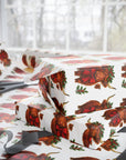 Gift boxes wrapped in highland cow patterned paper with scissors on a white background