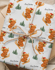 Christmas wrapping paper featuring a highland cow in a santa hat skiing down a snowy hill, set on a white background.