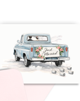 Wedding congratulations card with bride and groom driving away in just married vintage pickup truck with roses and tin cans with a coordinating pink envelope.