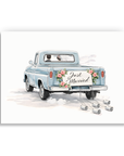 Wedding congratulations card with bride and groom driving away in just married vintage pickup truck with roses and tin cans.