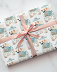gift wrapped in vintage theme wedding wrapping paper featuring a bride and groom making a quick getaway in their carriage with a sign that says "Just Married"