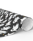 Roll of black wrapping paper with white ghost pattern on a white background