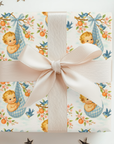Gift wrapped in vintage-esque baby design of little boy wrapped in blue gingham hanging from a tree.