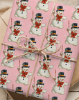 Pink christmas wrapping paper with asnowman pattern.