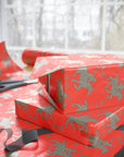 Red wrapping paper featuring silver polo players in a horse and rider pattern.