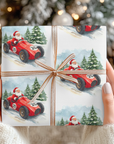 Gift box with Santa driving a red car design, held against a festive background.