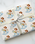 Gift wrapped in paper with cowboy baby and rocking horse design on a light background with horseshoes.