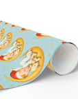 Roll of christmas wrapping paper with lamb and baby design on blue background.
