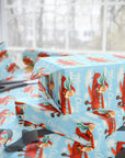 christmas wrapping paper featuring santa flying a biplane through blue sky.