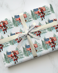 Gift wrapped in paper with Santa Claus and American flag design on a white surface.