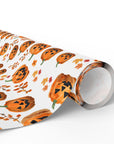 Roll of Halloween-themed wrapping paper with smiling jack-o'-lanterns and leaves on a white background.