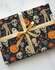 Gift wrapped in Halloween-themed paper with scary mummies and ghosts on a dark background.