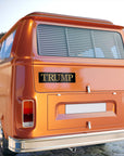 Orange van with 'TRUMP' branding on a blurred background