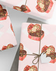 Vintage valentine chocolate box wrapping paper with heart shaped candy boxes on blush background.