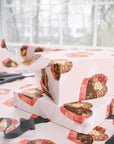 Retro wrapping paper that features heart-shaped candy boxes against a blush background.