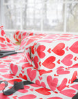 Watercolor pink and red hearts wrapping paper against a white background.