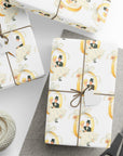 Vintage wedding wrapping paper featuring a retro bride and groom swinging on a golden wedding ring tied with a ribbon bow.