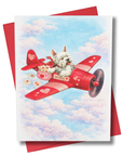 Greeting card with a westie dog in a red airplane against a blue sky with clouds.
